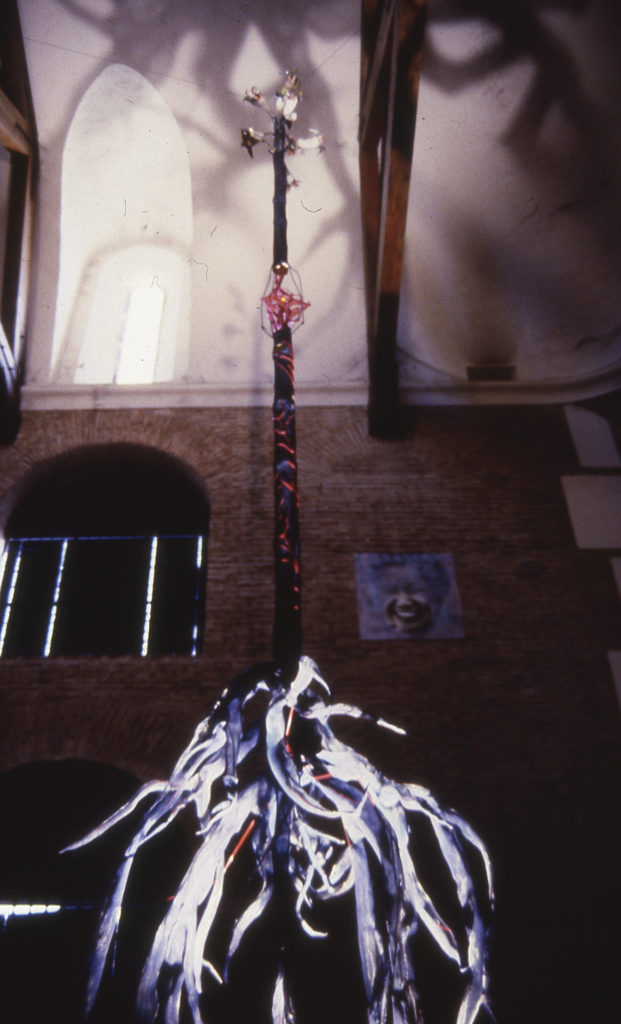 La risa de los pueblos Fragmento III: El árbol. Madera, hojalata, tela metálica pintada, cable eléctrico, bombilla y tubos de PVC. Altura total 12 metros. 1992
